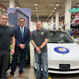 Three professionals standing with NAPA-branded vehicles in automotive service center