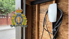 RCMP official crest mounted on wooden door frame with charging station visible