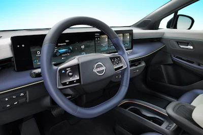 Modern car interior with blue steering wheel, digital dashboard display, and minimalist cabin design